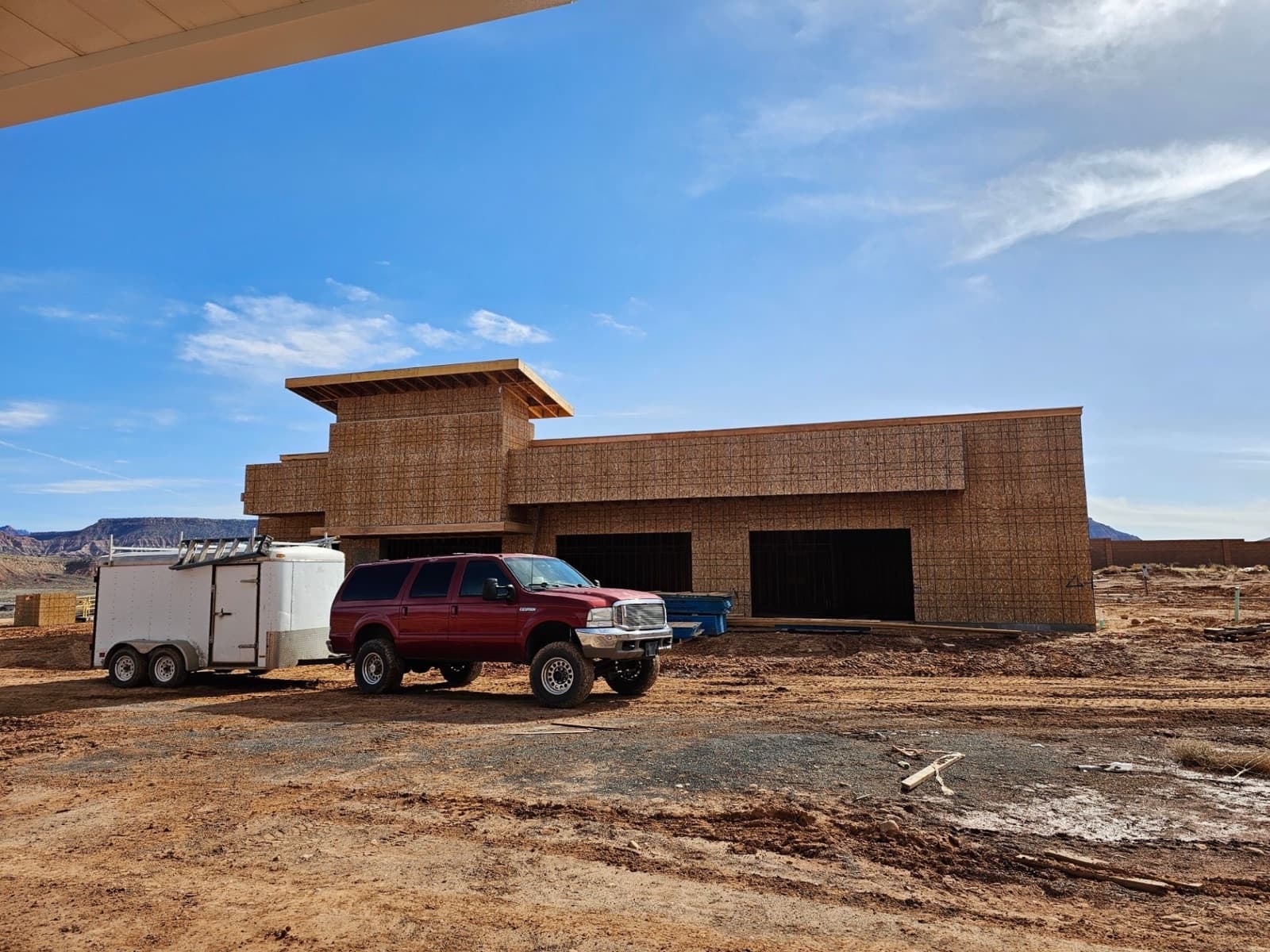 Framed home build with work trailer on site